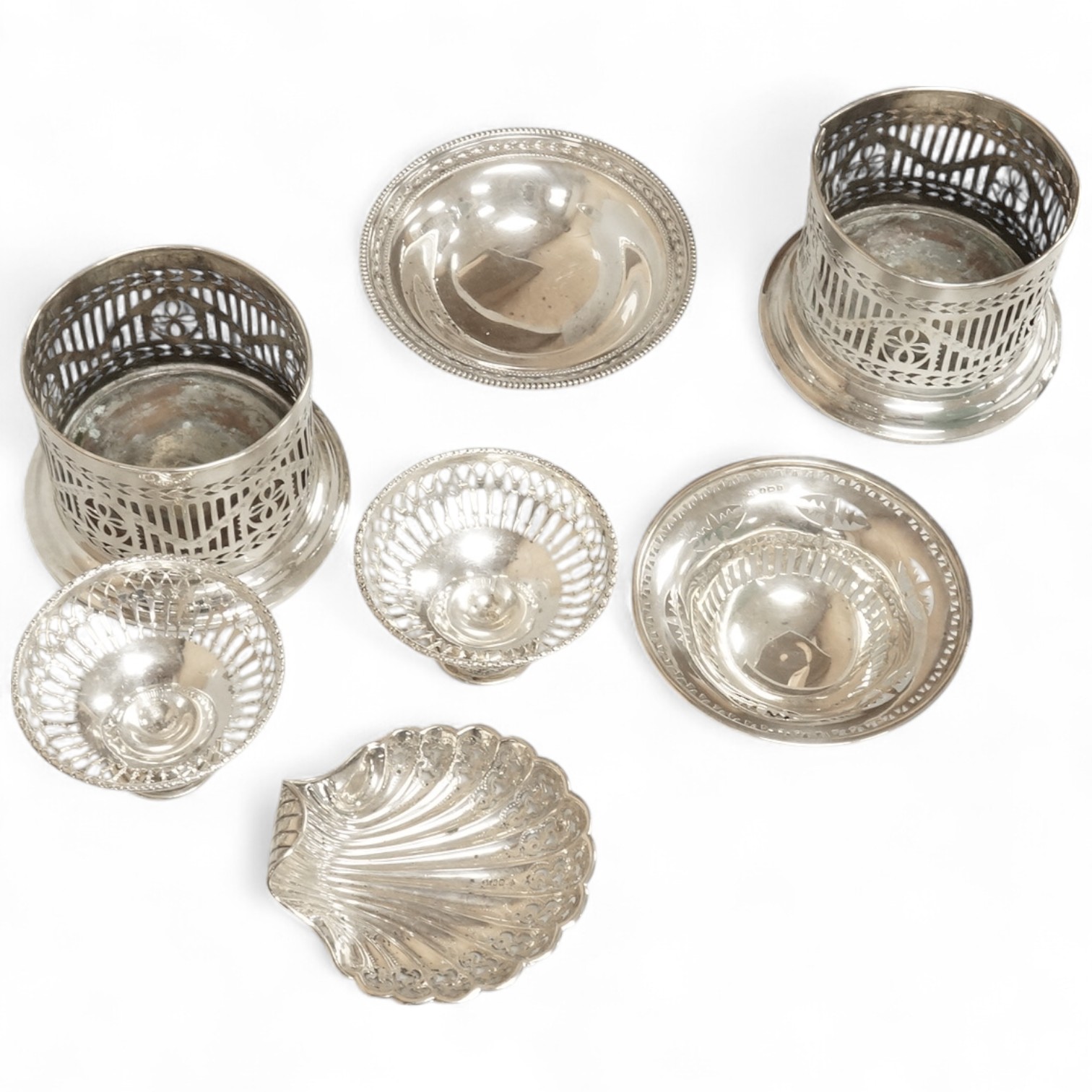 Two pairs of early 20th century silver bonbon dishes, including smallest by Mappin & Webb, Birmingham, 1913, height 6cm, together with an Edwardian silver butter shell and a pair of Edwardian silver mounted bottle coaste
